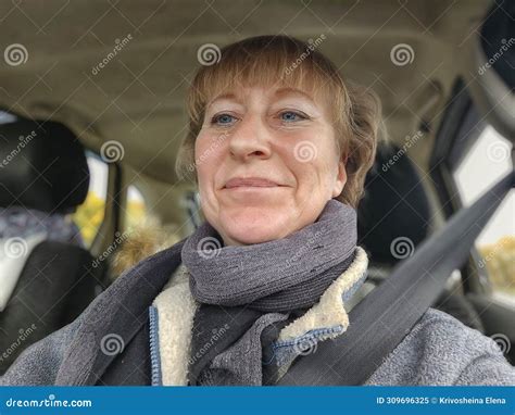 A Funny Cute Blonde Girl Or A Middle Aged Woman Driving A Car In Summer