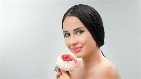 Portrait Of Smiling Beauty Naked Woman Posing With Tender Pink Flower