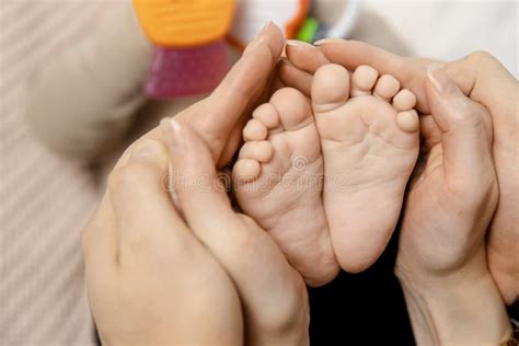 Baby Feet In Hands Of Parents Of Mom And Dad Love Is Continuation