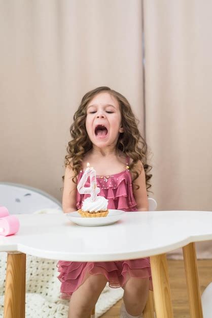 Premium Photo A Girl Blowing Out A Candle On A Birthday Cake