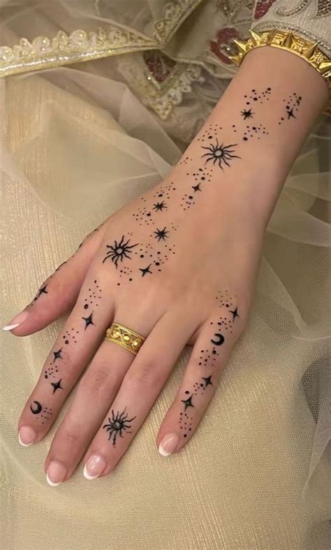 A Woman S Hand With Stars And Moon Tattoos On It