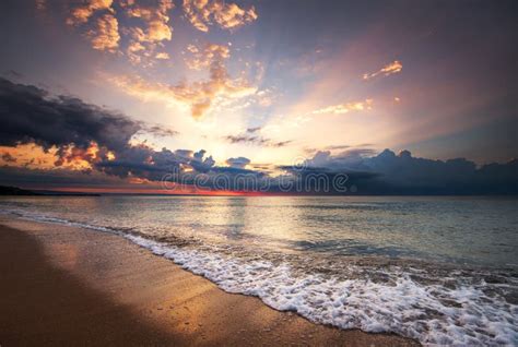 Colorful Ocean Beach Sunrise With Deep Blue Sky And Sun Rays Stock