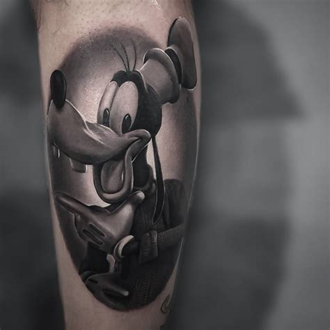 Black And Grey Goofy Tattoo On The Calf