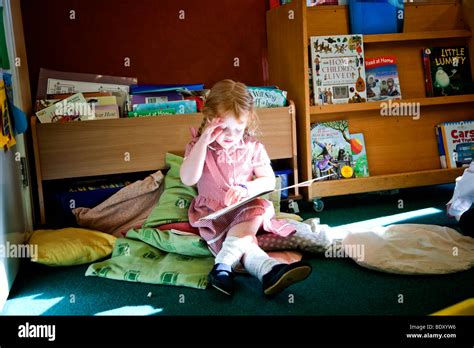 Girl reading a book alone in a classroom Stock Photo - Alamy