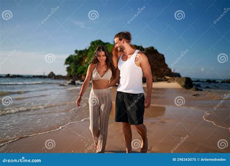 Romantic Couple Strolls On Beach At Sunset Holding Hands Woman Man