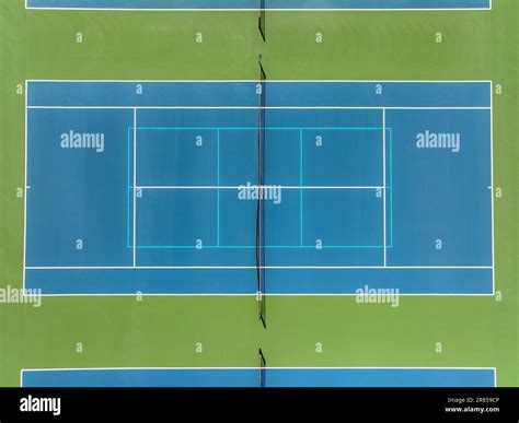 Aerial Photo Of Blue Tennis Courts With White Lines And Light Blue