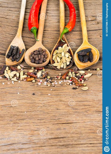 Closeup Of Four Wooden Cooking Spoons In A Row With Various Exotic Spices Two Red Chili Peppers