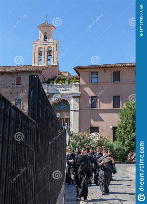 Group Of Catholic Priests In Black Cassocks Walking On A Street Of Rome