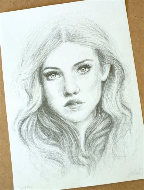 A Pencil Drawing Of A Woman S Face With Long Hair And Blue Eyes On Paper