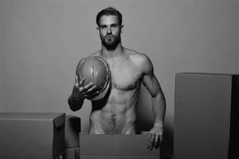 Guy With Torso Stands Naked Behind Boxes Man With Beard Stands On Yellow Background Seduction
