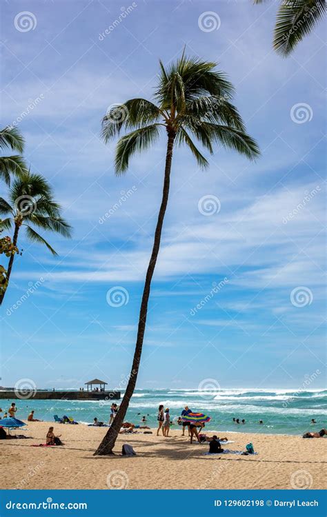 The Iconic Waikiki Beach During The Day With A Crowd Of People A