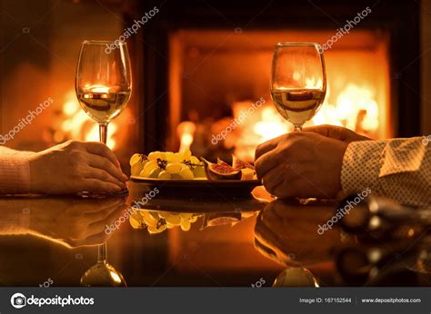 Young Couple Have Romantic Dinner With Wine Over Fireplace Background