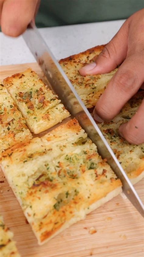 Someone Is Cutting Up Some Food On A Wooden Board With A Knife In Their