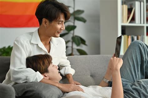 Premium Photo Carefree Male Gay Couple Using Browsing Internet On Digital Tablet And Relaxing