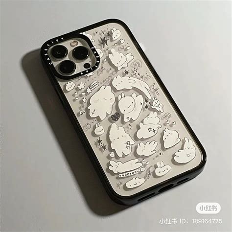 An Iphone Case With Many Stickers On It Sitting On A White Table Next