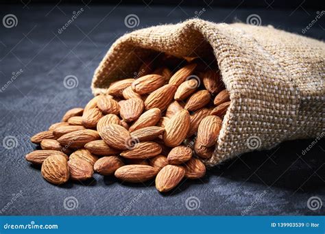 Almonds In Burlap Bag On Black Background With Copy Space Stock Image