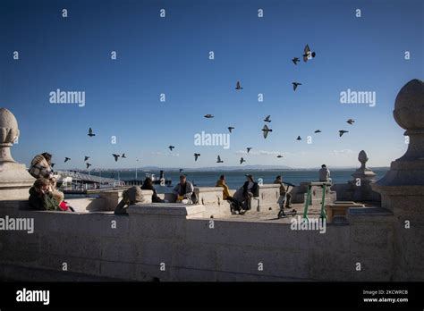 Las Palomas Vuelan Sobre Las Personas Sentadas A Orillas Del R O Tejo