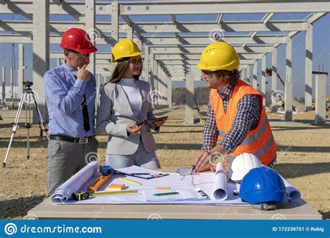 Hardhats Discuss A Project On Site Under Construction Stock Image