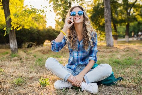 Jeune élégante jolie femme blonde souriante heureuse dans le parc aux beaux jours d été Photo