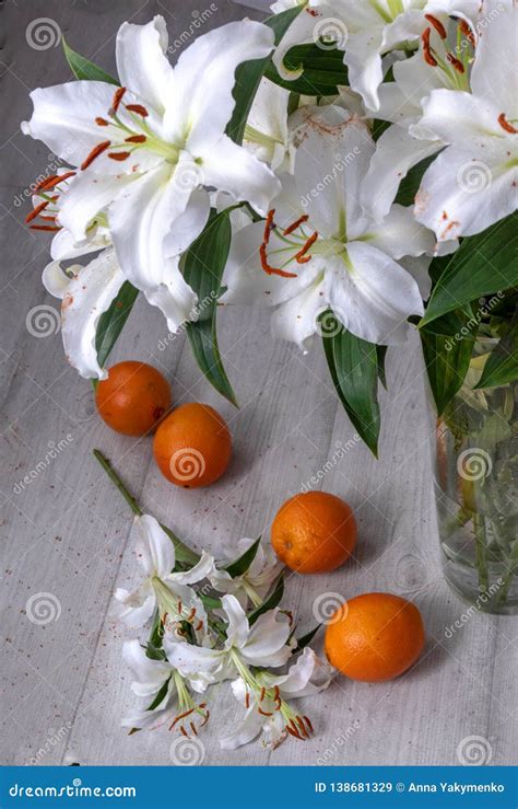 Lirios Blancos Hermosos En Un Florero Y En El Piso Imagen De Archivo