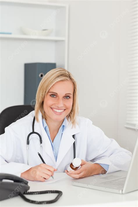 Physician Jotting Notes And Examining Medication Vial Treatment Exam