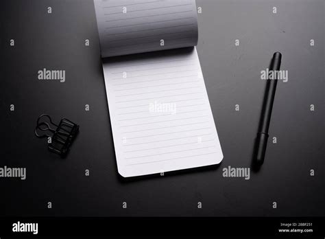 Black Style Set Notepad Pen And Paper Clips On Black Background Stock