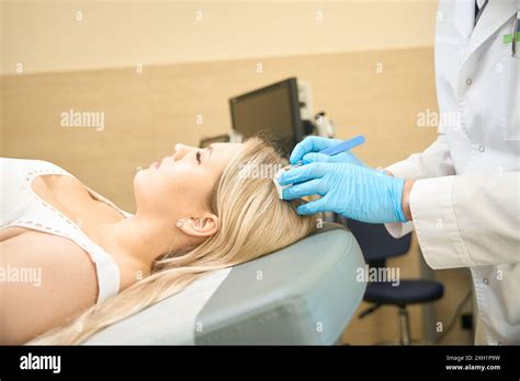 Dermatologist Performing Surgical Excision Of Sebaceous Cyst On Patient