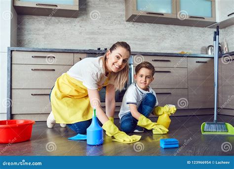 El Hijo Ayuda A La Mam A Limpiar En La Cocina Foto De Archivo Imagen