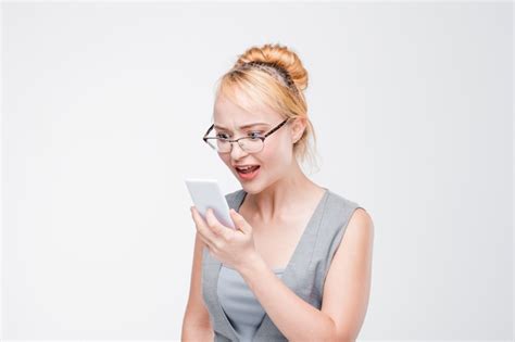 Premium Photo Irritated Young Girl In Glasses With Mobile Phone Looks