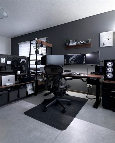 An Office With Two Desks And Several Computer Screens On The Wall