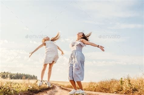 Happy Mother And Daughter Jumping In Field Sky Background Bottom View