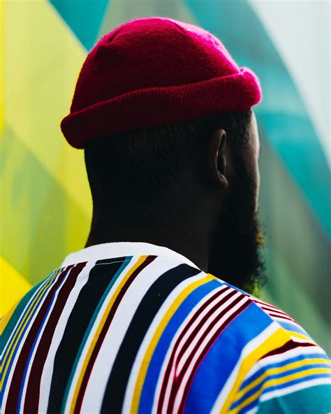 Man Wearing Red Hat And Multicolored Shirt Facing Back Photo Free