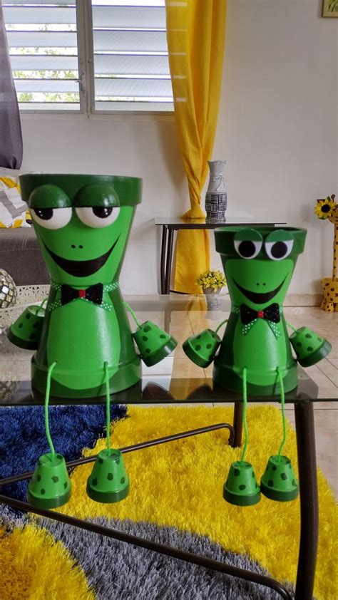 Two Green Robot Statues Sitting On Top Of A Table In Front Of A Yellow Rug