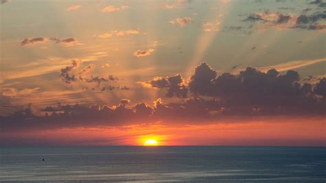 绝美日落，太阳缓缓沉落地平线，大海与云彩共绘壮丽4k壁纸（3840x2160高清下载） 墨鱼部落格