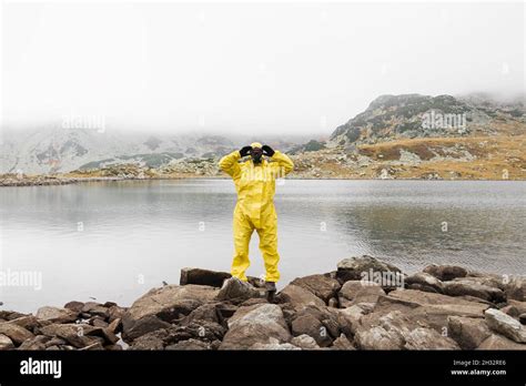 Person Wearing Yellow Hazmat Suit During Covid Pandemic Stock Photo