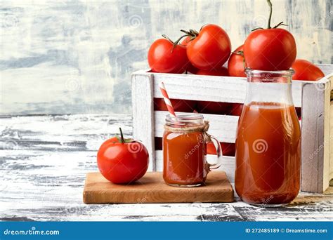 Box With Ripe Tomatoes And Tomato Juice In A Glass Bottle Stock Image