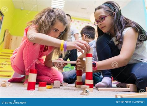 Duas Meninas Que Jogam Junto Blocos De Madeira Do Brinquedo No