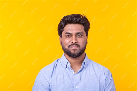 Premium Photo Indian Handsome Man Wearing Blue Shirt On Yellow Wall