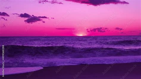 Spectacular pink purple sunset over ocean, waves breaking on beach. Amazing scene of sunset ...