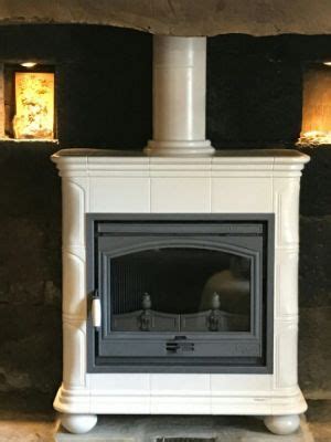 A White Fireplace With Three Lit Candles On It S Sides And A Black