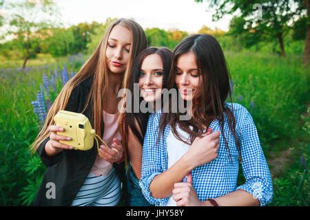 Drei Hipster Mädchen Blonde und Brünette unter Selbstportrait auf Polaroid Kamera und lächelnd