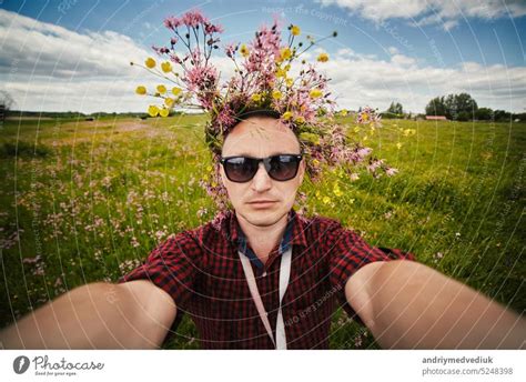 Junger Lächelnder Mann Mit Wildblumenkranz Und Sonnenbrille Macht Ein