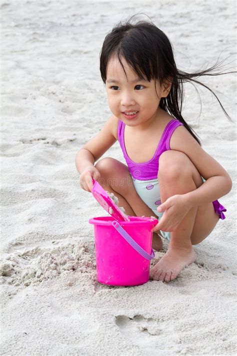 Petit Jouer Chinois Asiatique De Fille Poncent Avec Des Jouets De Plage