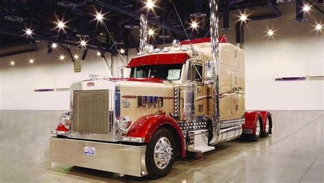 A Red And Gold Semi Truck Parked In A Warehouse With Lights On The