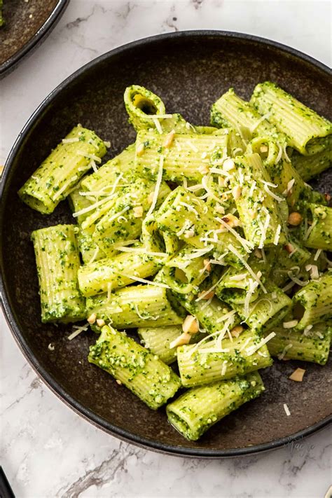 Top Down View Of A Dark Brown Bowl Filled With Pesto Covered Pasta