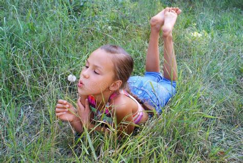 Fille De La Pr Adolescence Soufflant Sur Le Pissenlit Image Stock