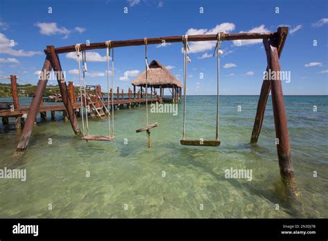 Swing set and Tiki hut gazebo on dock with turquoise water at Rancho ...