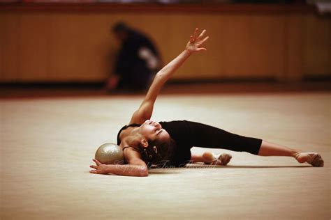 A Woman Is Laying On The Floor With Her Hands In The Air While Holding