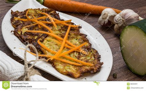 Fried Zucchini And Potato Pancakes Seasoned With Garlic And Herbs Decorated Grated Carrots