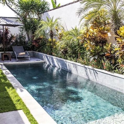 An Outdoor Swimming Pool Surrounded By Greenery